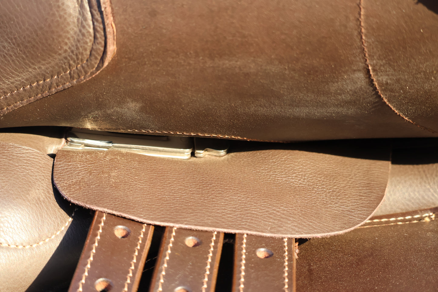 Close-up of a brown leather bag with visible stitching and strap.