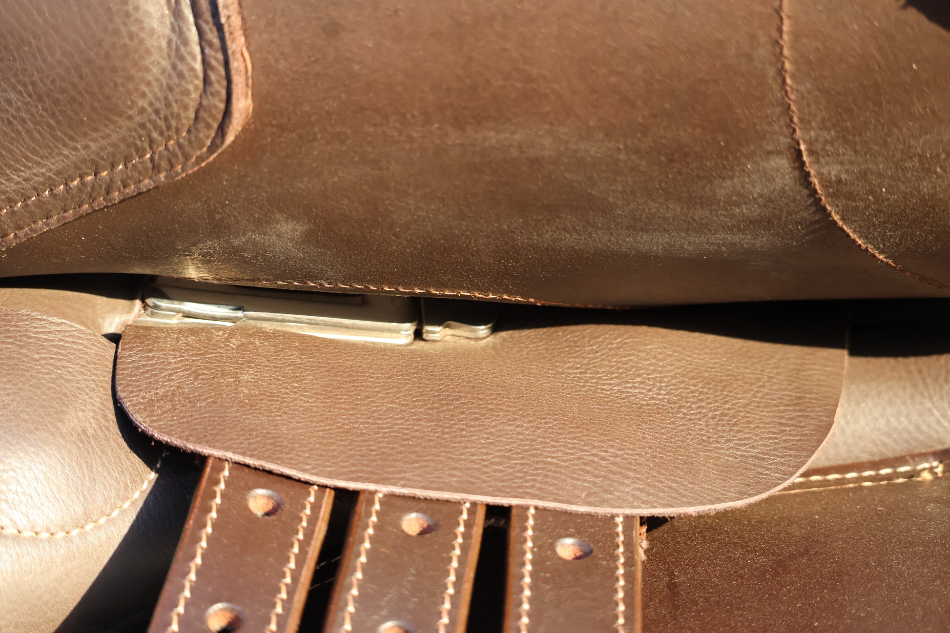 Close-up of a brown leather bag with visible stitching and strap.